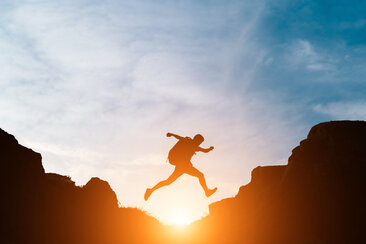 man jump through gaps hills